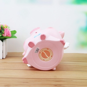 Hucha de cerdito rosa con alas y lazo azul, vista inferior con tapón de monedas