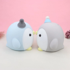 Detalle de huchas de pingüinos con gorros de punto en un fondo decorativo acogedor