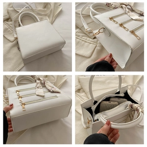 Detail view of white square handbag showing golden zippers and floral scarf handle wrap