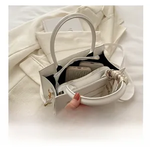 Detail view of white leather tote interior with silk scarf and separate zipper pouch