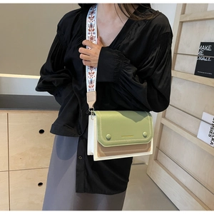 Detail of trendy color-block crossbody bag with floral embroidery wide shoulder strap