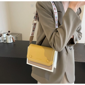Close-up of color-block square crossbody bag with embroidered wide strap details
