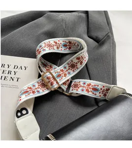 Detail of adjustable ethnic style woven shoulder strap with floral patterns on white bag