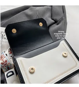 Detail view of the secure magnetic closure and wide patterned strap on the contrast shoulder bag
