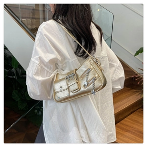 Sac à bandoulière doré métallisé chic avec breloque étoile porté par un mannequin