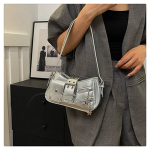 Sac à bandoulière argenté avec boucles et pendentif étoile porté par un mannequin