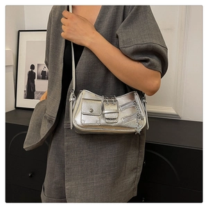 Détails du sac à bandoulière argenté avec pendentifs étoile et fermetures éclair
