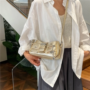 Sac porté épaule Y2K doré métallisé avec pendentif étoile porté par un mannequin