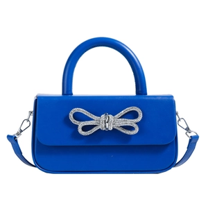 Blue crossbody bag with a sparkling rhinestone bow and stylish top handle on white background