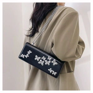 Detail of glossy black butterfly crossbody bag featuring 3D silver butterfly ornaments