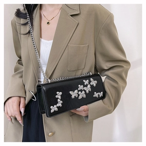 Detailed view of black matte leather chain bag with 3D silver butterfly ornaments