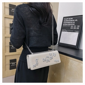 Chic cream leather crossbody bag with silver 3D butterflies worn by a model in lifestyle set