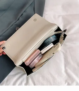 Detailed view of the spacious inner compartment of the beige butterfly flap bag