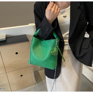 Detailaufnahme der hellgrünen Web-Tasche mit Herzanhänger und silberner Kette