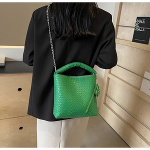Details der hellgrünen Eimertasche mit Schlangenmuster, Webgriff und silberner Kette