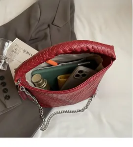Detailansicht der weinroten geflochtenen Tasche mit Kette und geräumigem Innenraum