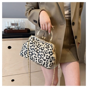 Detail of leopard print straw clutch with gold metal handle and vintage bead clasp
