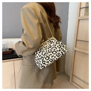 Detail of leopard print evening bag with rhinestone clasp and gold chain strap