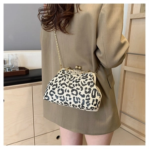 Detail of leopard print straw handbag with rhinestone clasp and gold chain strap