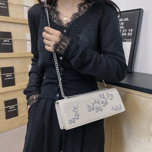 Chic cream leather crossbody bag with silver butterfly accents and chain strap
