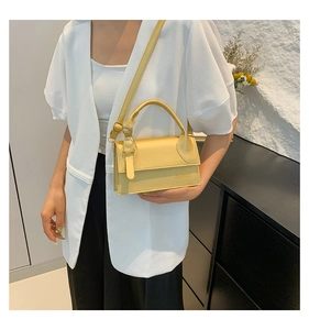 Détail d'un mini sac à main jaune avec lettrage JINGPINPIJU et fine bandoulière