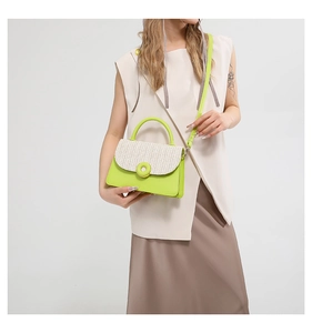 Detail of trendy crossbody bag featuring neon green leather and woven straw texture