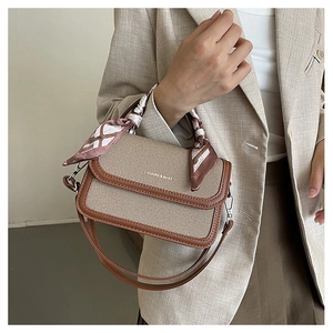 Detail of vintage canvas and leather crossbody bag with decorative scarf handle