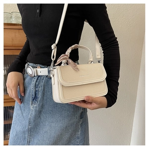 Ivory textured handbag with silk scarf wrapped handle and crossbody strap detail