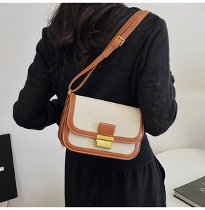 Linen canvas crossbody bag featuring brown leather trim and metallic buckle shown on model