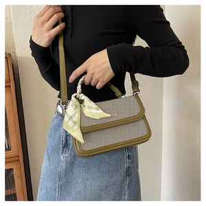 Detail of striped crossbody bag with olive leather trim and silk scarf wrapped handle