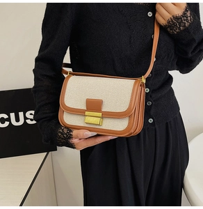 Detail of the vintage canvas and brown leather flap bag with gold metallic lock closure