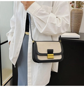 Detailed view of linen patchwork crossbody bag with black leather trim and gold metal buckle