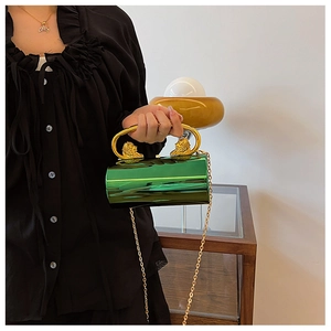 Detail of green metallic evening bag featuring gold lion head hardware and chain strap