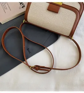 Detail of adjustable leather strap and canvas stitching on vintage square crossbody bag