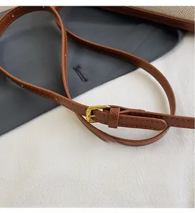 Close-up of adjustable brown leather shoulder strap with premium gold metal buckle