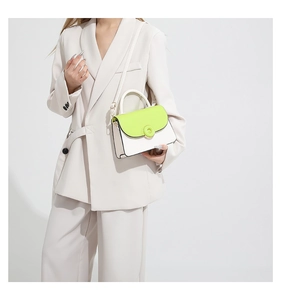 Gros plan sur le sac carré contrasté en vert néon et blanc cassé avec bandoulière