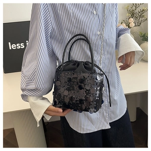 Detailed view of black sequined bucket bag with drawstring closure and chain strap