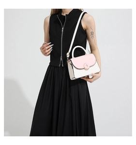 Détail du sac bandoulière bicolore rose et crème avec fermoir métallique doré rond