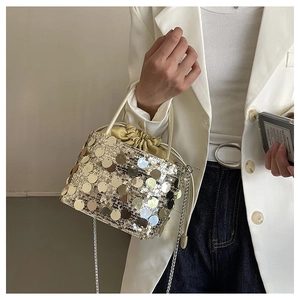 Close-up of stylish mini sequin bucket bag with drawstring liner and metal chain