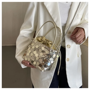 Detail of champagne gold sequin bucket bag with drawstring liner and chain strap