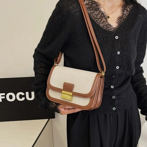 Vintage linen and brown leather crossbody bag with gold buckle shown on model