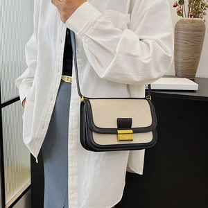 Chic linen and black leather patchwork crossbody bag with a vintage gold metal lock