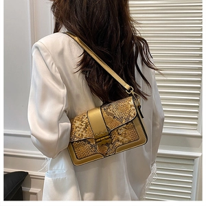 Detailed view of snakeskin pattern shoulder bag with vintage gold clasp on model