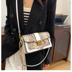 Close-up of snakeskin pattern shoulder bag with vintage gold clasp and chain detail