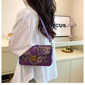 Detail of purple snakeskin patchwork handbag with vintage gold buckle on model