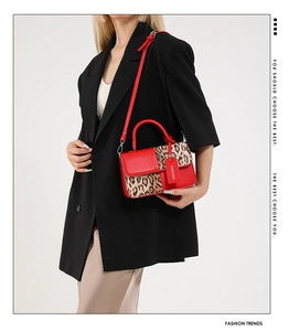 Detail of red leather and leopard print mini handbag styled with a black suit jacket