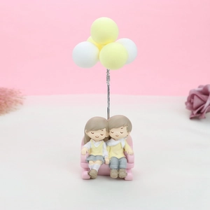 Vue détaillée du couple de figurines sur canapé avec des ballons colorés décoratifs