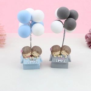 Détail de figurines de couple avec ballons colorés sur socle Life is Simple