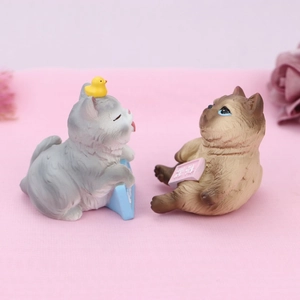 Close-up of resin cat figurines with humorous campus themes for desk decoration