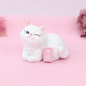 Cute white resin cat figurine with blue heterochromia eyes and a small pink sign